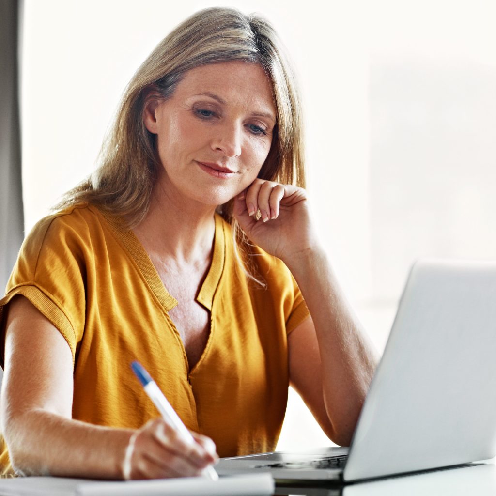 Shot of a mature woman using a laptop at home to research blepharoplasty.