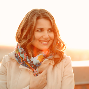 Woman smiling wearing a coat and scarf