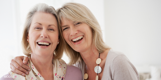 Two mature women laughing.