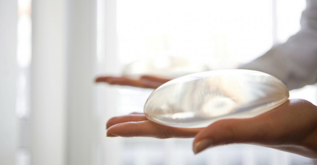 Woman holding breast implants