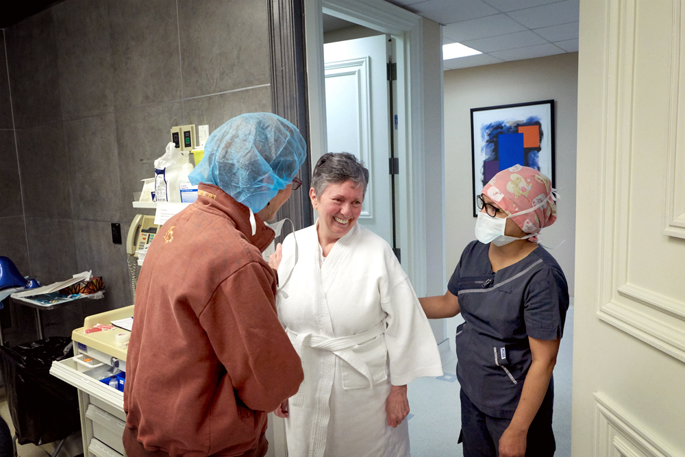 Nurses talking with happy patient after treatment