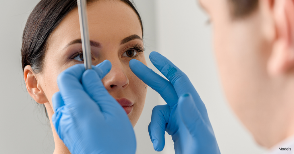 Doctor handling woman's nose (models)