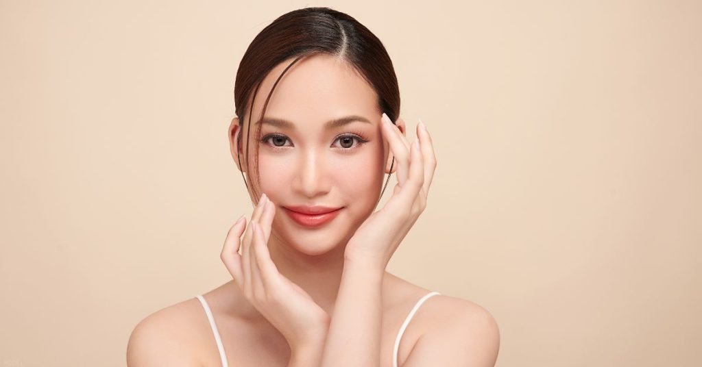 Woman touching her face after double eyelid surgery (model)